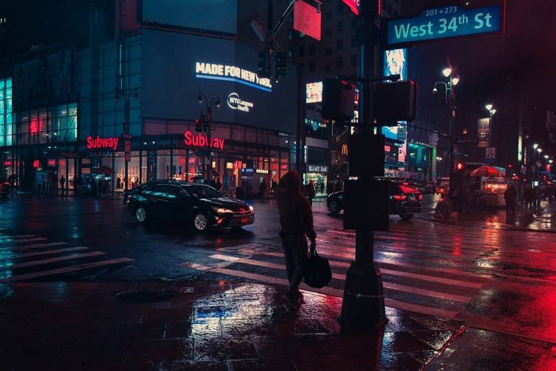 person standing beside traffic light during night